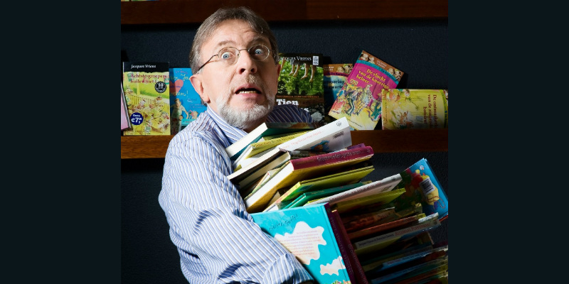 Jacques Vriens met een stapel boeken